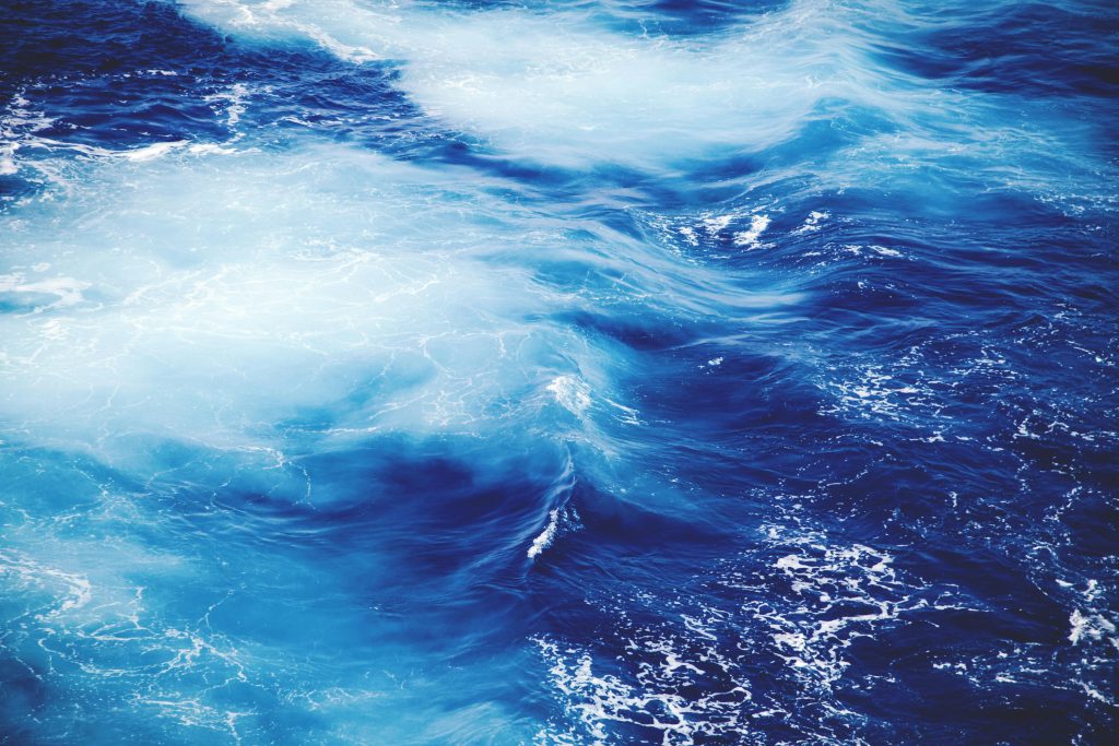 Dynamic and vibrant view of ocean waves, showcasing the deep blue and white froth of the sea.